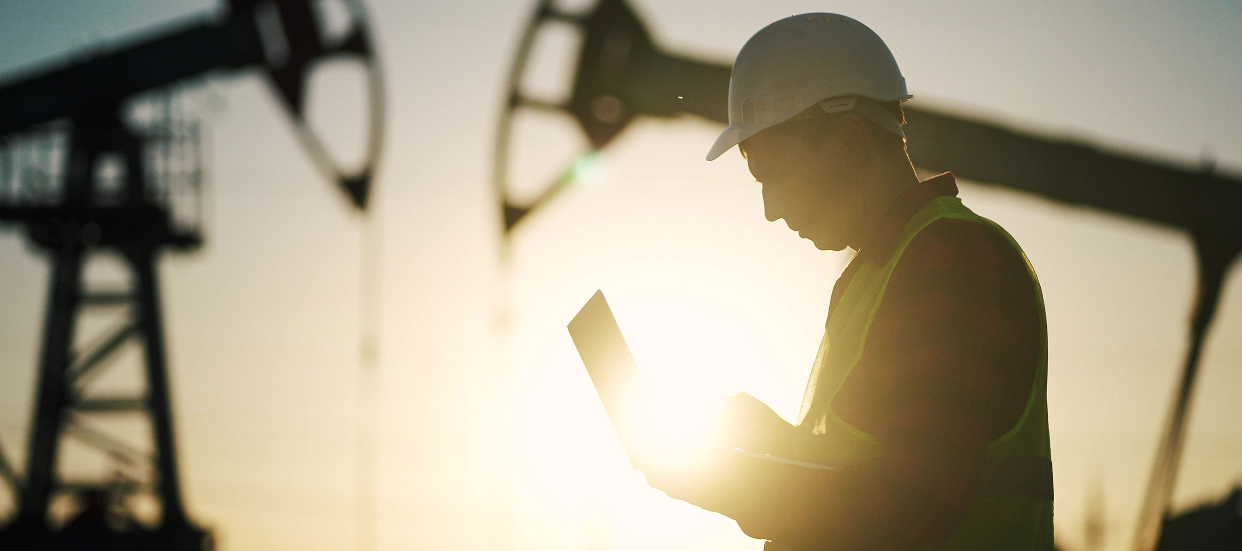 A guy at a power plant holding a laptop