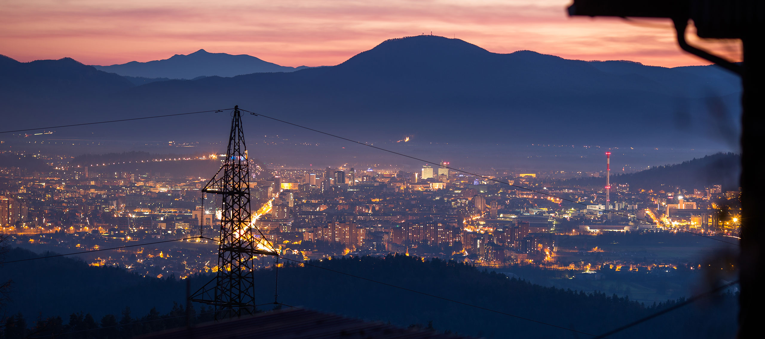 A power line at night time with a city skyline in the background